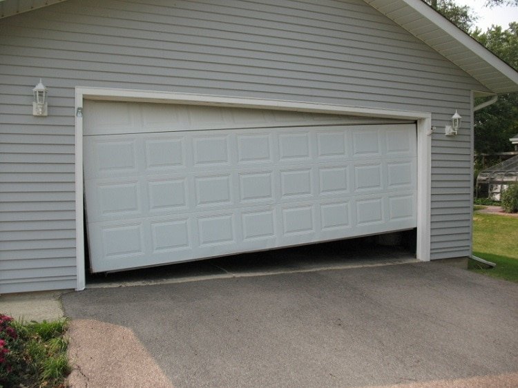 Two-car residential garage with crooked white garage door