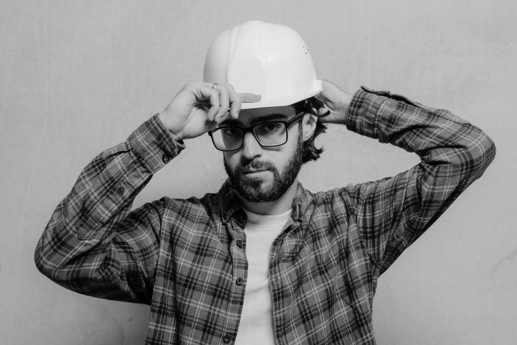 Man in flannel shirt, glasses and white hardhat