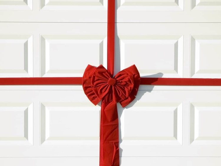 White, paneled new garage door with red gift bow